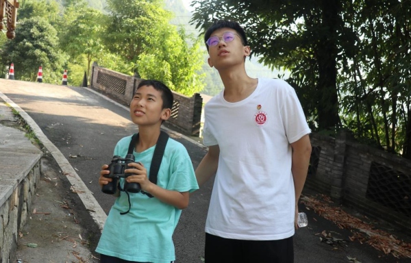 服务团成员带领小朋友户外观鸟。taptap点点体育供图