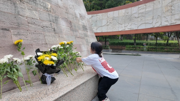 屈美芸在烈士纪念碑前献花。taptap点点体育美术学院供图